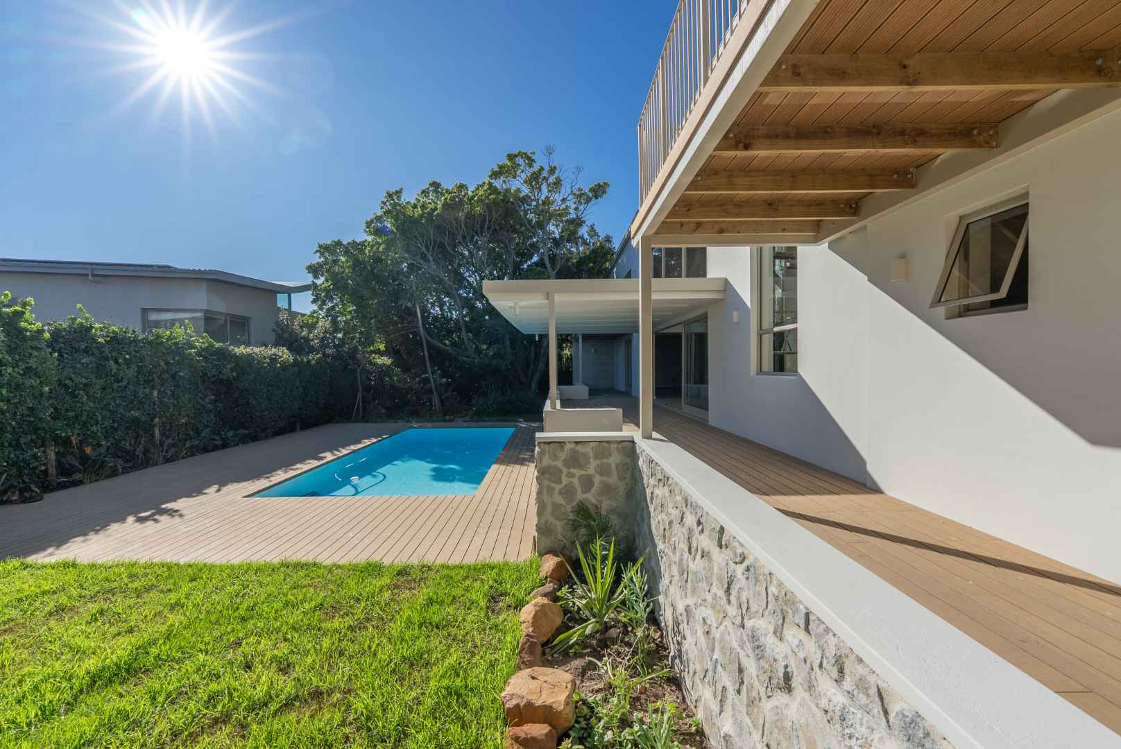 A Camps Bay home with pool, deck, and modern architecture under a clear blue sky
